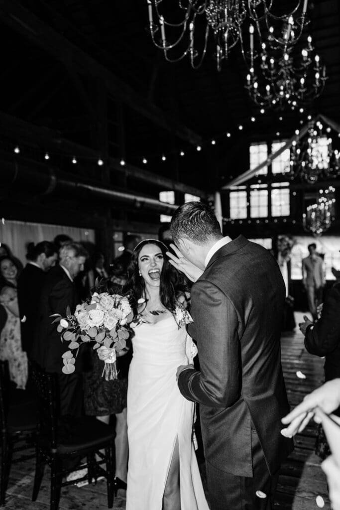 Black and White photograph of bride and groom celebrating at wedding ceremony.