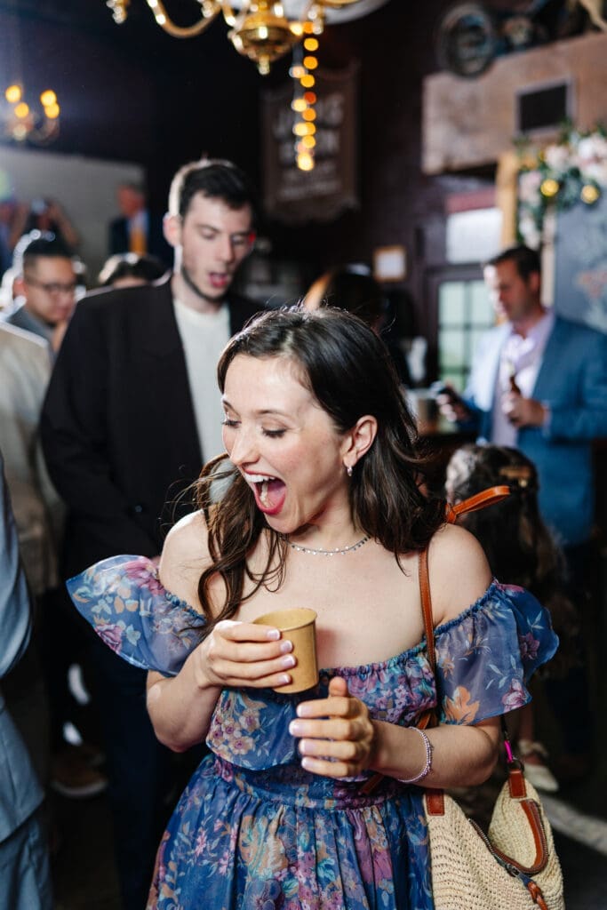 Wedding guest laughing and dancing at rustic wedding reception.