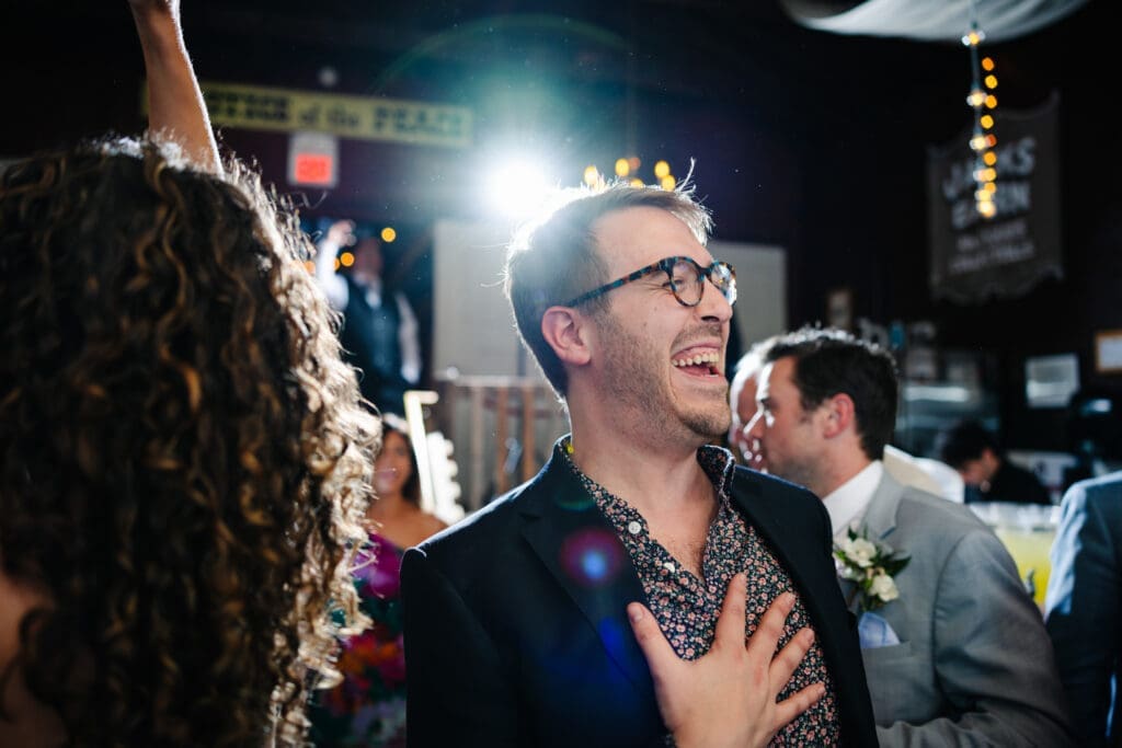 Guest laughing at rustic wedding reception.