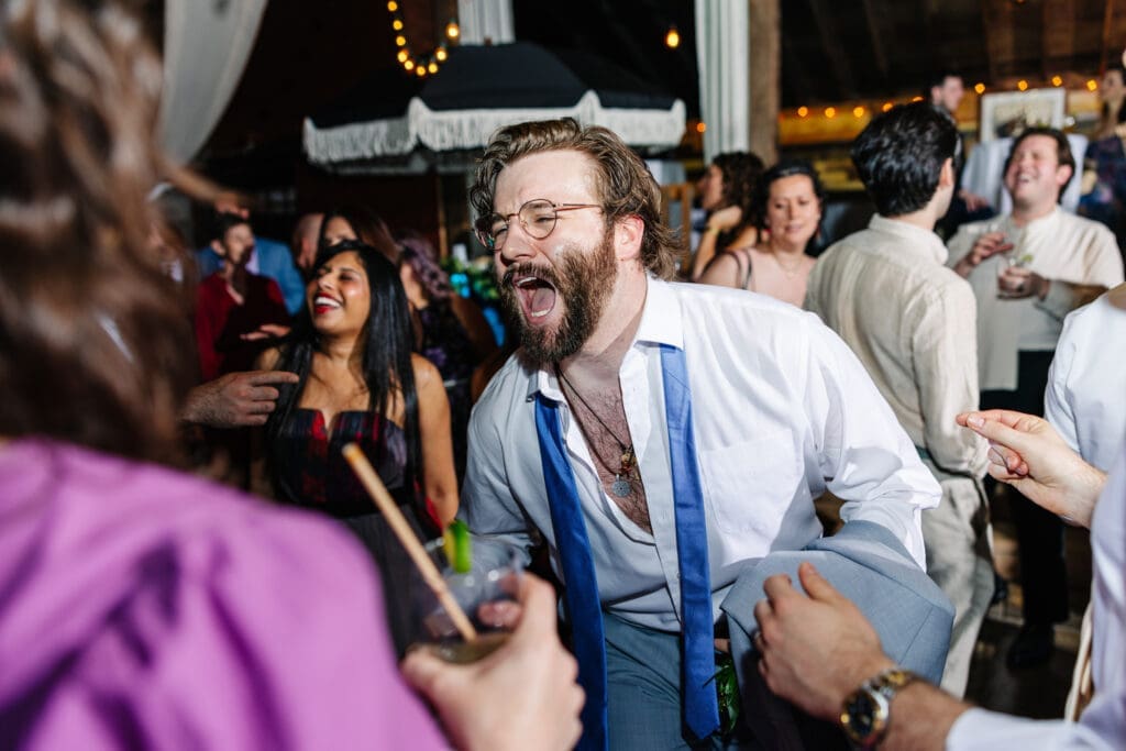 Wedding guest singing at rustic reception at barn.