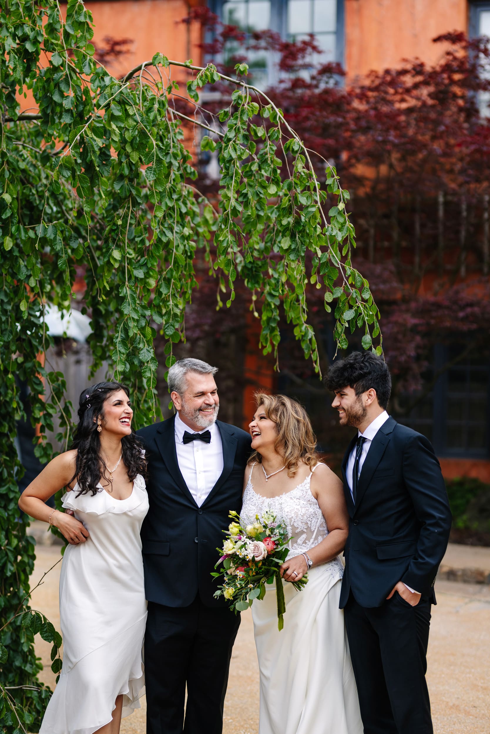 Bride and groom with their adult children during a 25th wedding anniversary vow renewal at Grounds For Sculpture in Hamilton Township, New Jersey