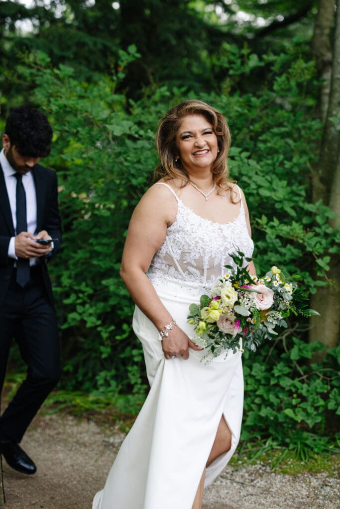 Bride holding her bouquet among the gardens at Grounds For Sculpture during a 25th wedding anniversary vow renewal in Hamilton Township, New Jersey.