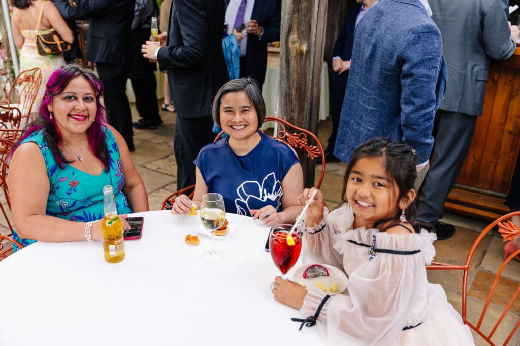 Family members enjoying cocktail hour on the terrace at Rat's Restaurant during a 25th wedding anniversary vow renewal in Hamilton Township, New Jersey.